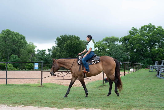 Rider's Western boot in the stirrup on a horse at Highbrow Ranch in Caldwell, Texas — the best boots for riding