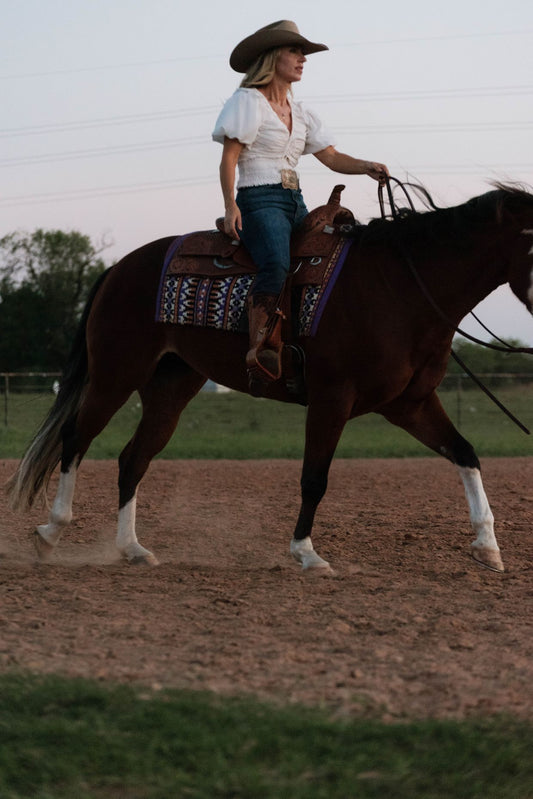 Adult rider on a beginner-safe paint horse in the arena at Highbrow Ranch in Caldwell, Texas