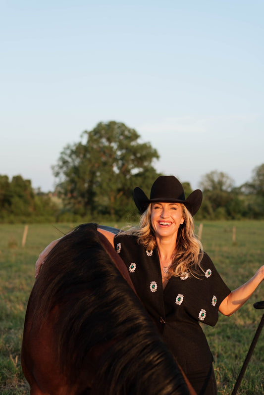 Kate Evans, founder of Highbrow Ranch, with a beginner-safe paint horse in Caldwell, Texas
